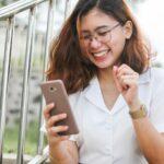 woman in white button up shirt holding silver iphone 6