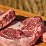 a pile of raw meat sitting on top of a wooden cutting board
