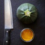 black handled knife beside green vegetable