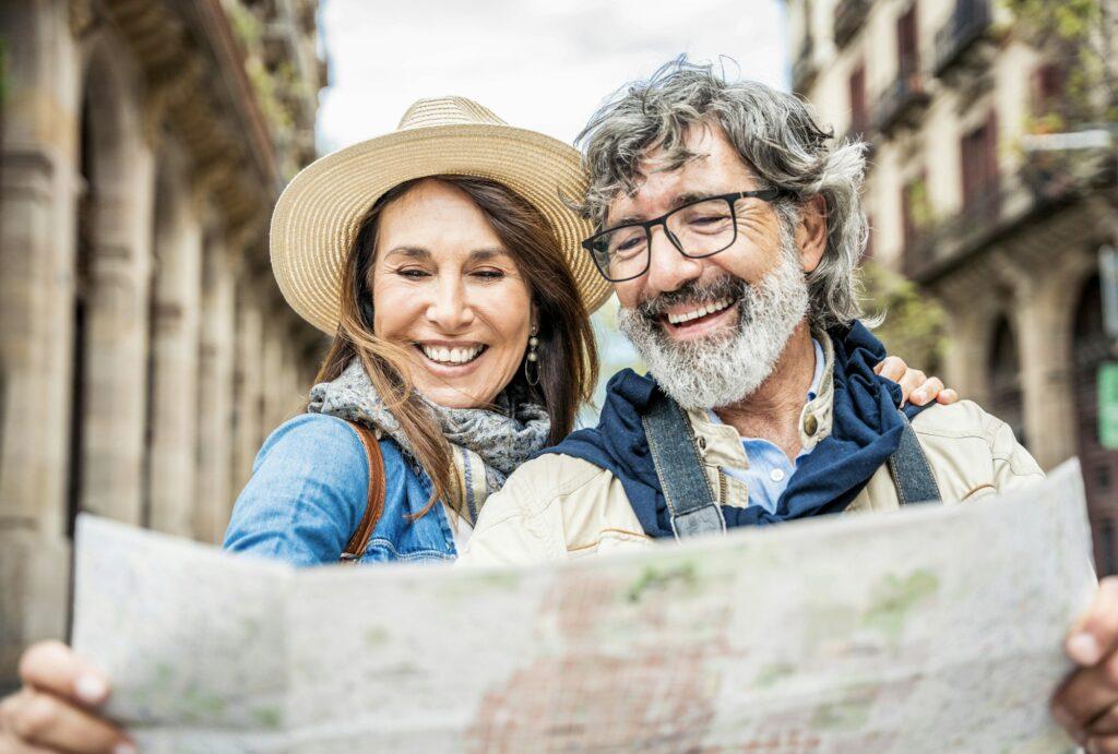 Married couple of tourists sightseeing city street with map