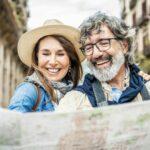 Married couple of tourists sightseeing city street with map