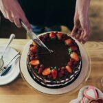 Cropped image of woman cutting delicious chocolate cake