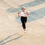 Young curvy female in sportswear jogging on roof.
