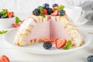 Charlotte Royale Cake with strawberry cream inside and decorated berries. Delicious summer cake.