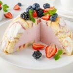 Charlotte Royale Cake with strawberry cream inside and decorated berries. Delicious summer cake.