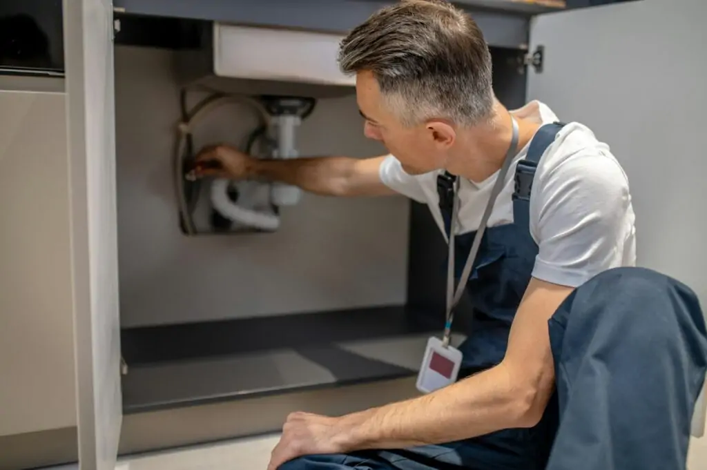 Man putting ball valve on water pipe