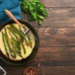 Omelet with asparagus. Frittata or scrambled with asparagus in frying pan with parsley and pepper on