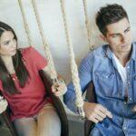Portrait of couple sitting in swings