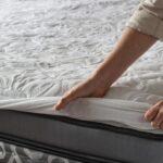 Woman putting protective mattress pad on a new mattress