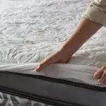 Woman putting protective mattress pad on a new mattress