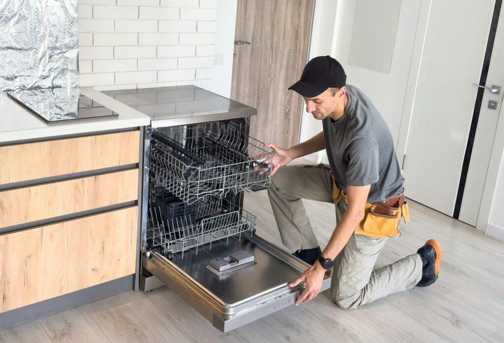 Worker repair dishwasher at home.