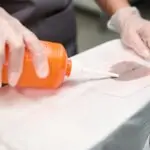 Laundry worker treating dirty spots on clothes before dry cleaning