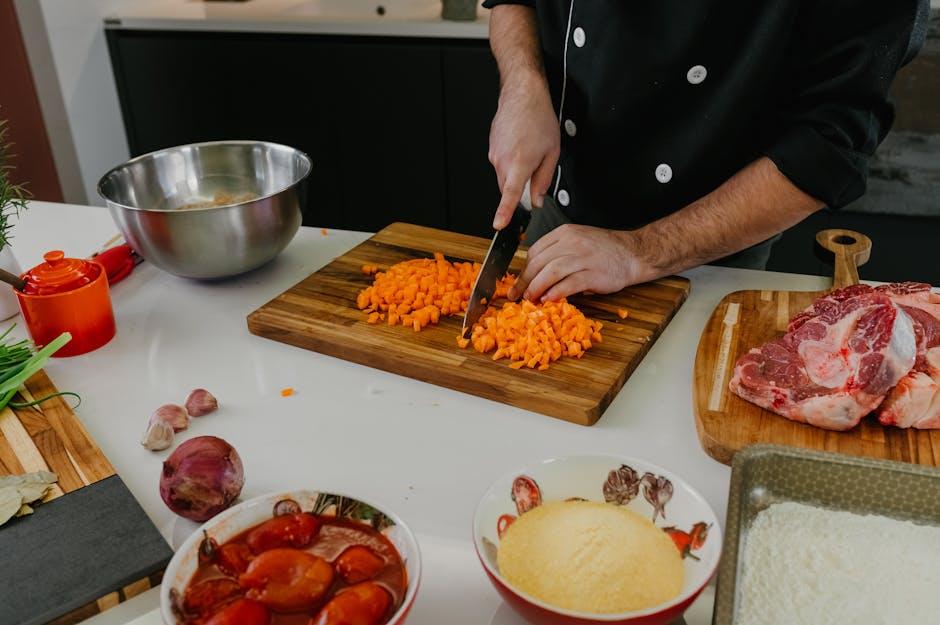 Chef coupant des carottes sur une planche dans une cuisine moderne pour réussir un risotto parfait.