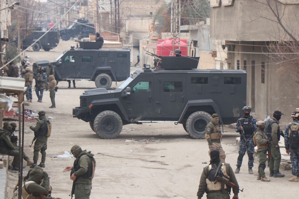 Forces armées dans des véhicules blindés dans les rues d'Al Hasakah lors d'une opération militaire.
