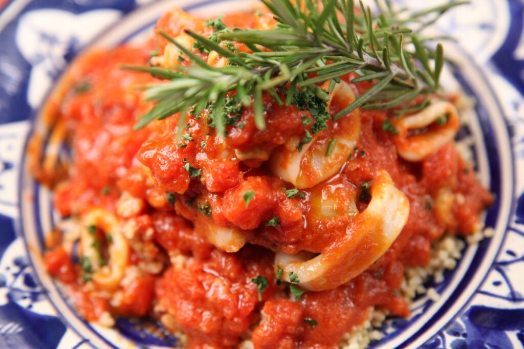 Délicieux plat de fruits de mer à l'italienne garni d'herbes fraîches et de sauce tomate savoureuse.