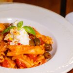 Pâtes savoureuses avec garniture d'olives et de fromage, idéales pour les thèmes culinaires.