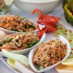 Plats asiatiques vibrants avec des ingrédients frais et des garnitures sur une table dressée.