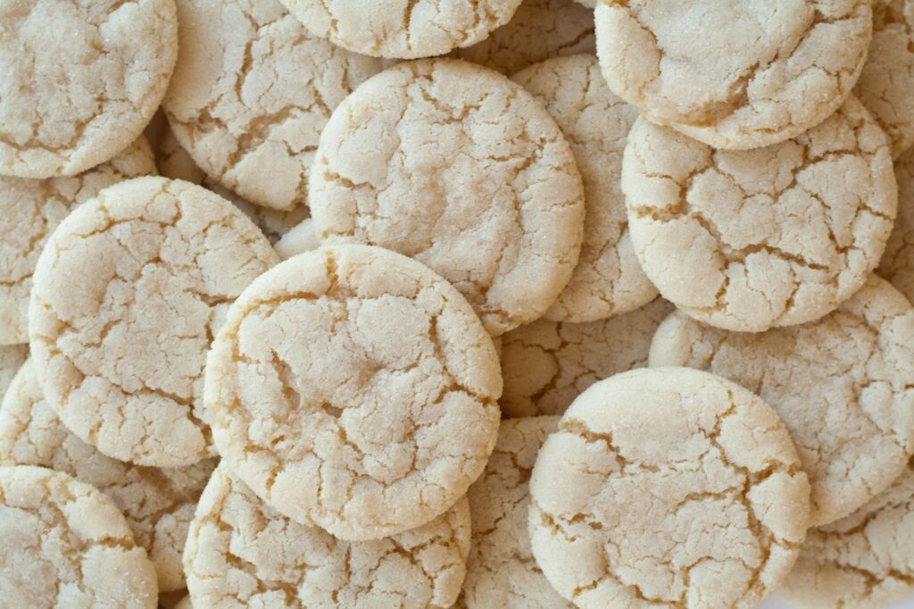 Gros plan de biscuits au sucre faits maison avec une surface craquelée, mettant en valeur leur texture.