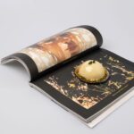 Un dessert gastronomique est posé sur un livre d'art, capturant un mélange d'art culinaire et visuel.