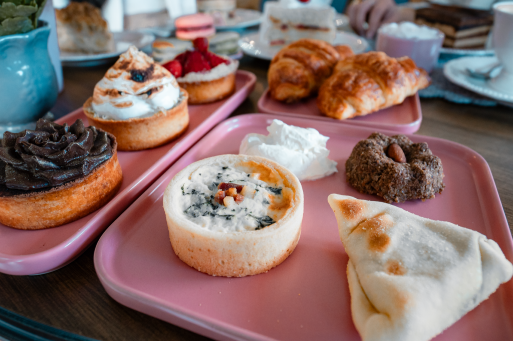 Un délicieux assortiment de pâtisseries présentées sur des plateaux roses, parfait pour le brunch ou l'heure du thé.