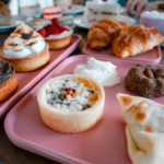 Un délicieux assortiment de pâtisseries présentées sur des plateaux roses, parfait pour le brunch ou l'heure du thé.