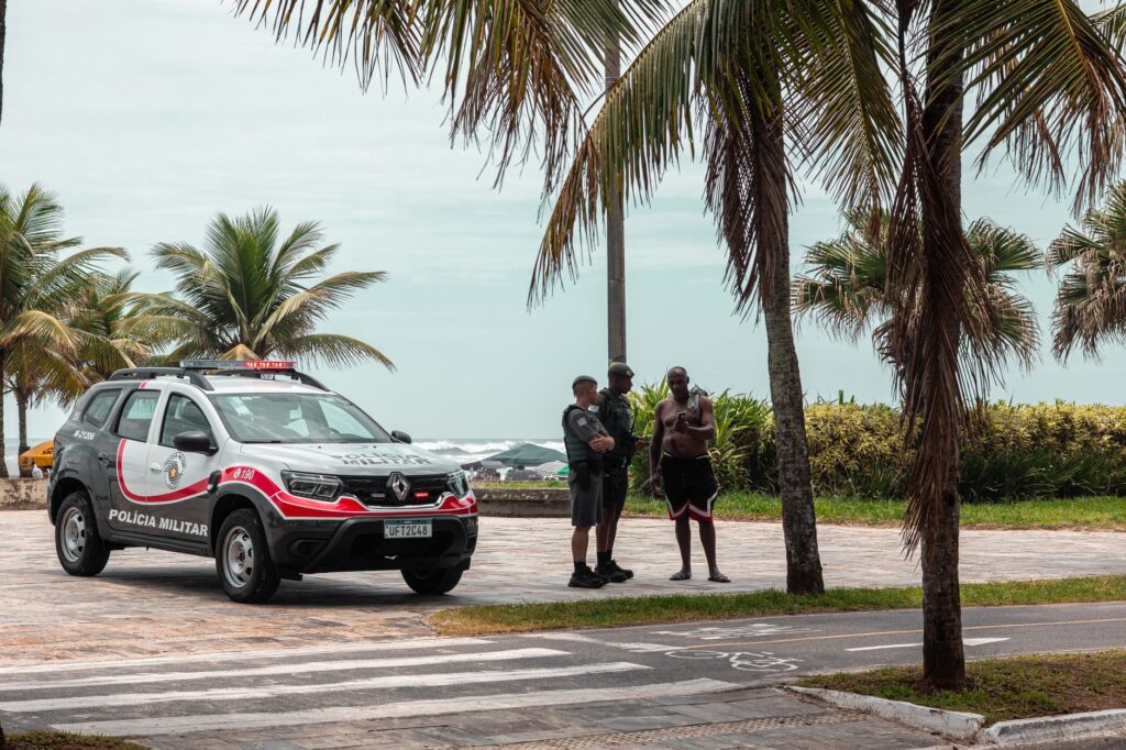 Des policiers en service près d'une plage bordée de palmiers au Brésil.