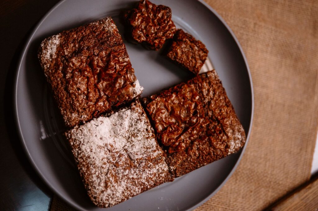 Gros plan sur des brownies au chocolat fraîchement sortis du four, servis dans une assiette, parfaits pour les amateurs de desserts.