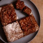Gros plan sur des brownies au chocolat fraîchement sortis du four, servis dans une assiette, parfaits pour les amateurs de desserts.