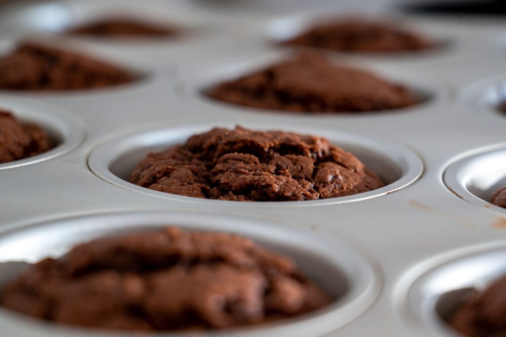 Gros plan sur des muffins au chocolat fraîchement cuits refroidissant dans un moule à muffins. Dessert ou en-cas parfait.