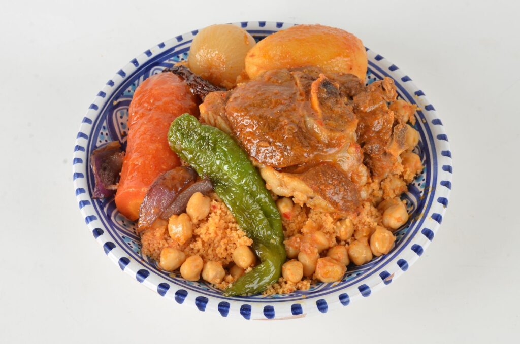 Une assiette colorée de couscous marocain composée d'agneau tendre, de légumes et de pois chiches.