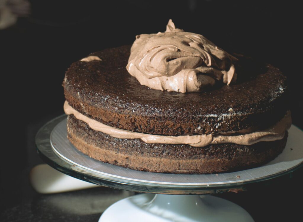 Un gâteau au chocolat à étages, somptueux et recouvert d'un glaçage riche, présenté avec élégance. Idéal pour les amateurs de desserts.