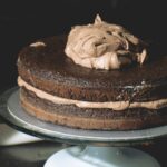 Un gâteau au chocolat à étages, somptueux et recouvert d'un glaçage riche, présenté avec élégance. Idéal pour les amateurs de desserts.