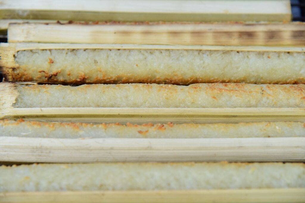 Gros plan sur du riz gluant cuit traditionnellement dans du bambou, une spécialité populaire d'Asie du Sud-Est.