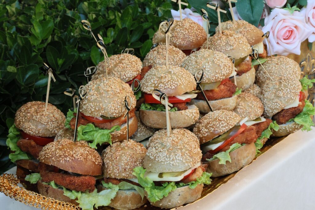 De délicieux mini-burgers au poulet avec laitue, tomate et pains au sésame, parfaits pour les événements.