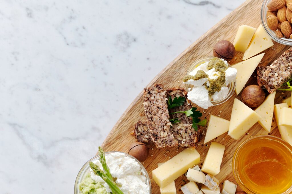 Délicieux plateau de fromage gourmet avec une variété de fromages, noix et miel sur une planche en bois rustique.