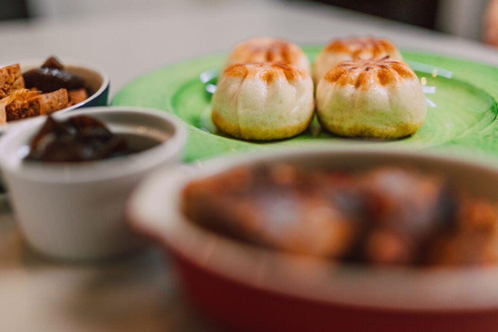 Gros plan sur des pains à la vapeur appétissants avec des accompagnements sur une table, parfait pour la photographie culinaire.