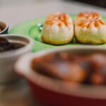 Gros plan sur des pains à la vapeur appétissants avec des accompagnements sur une table, parfait pour la photographie culinaire.