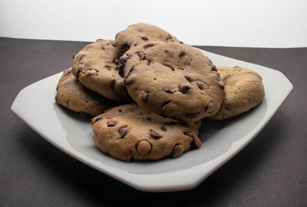 Gros plan sur des cookies aux pépites de chocolat fraîchement cuits sur une assiette, parfaits pour le dessert.