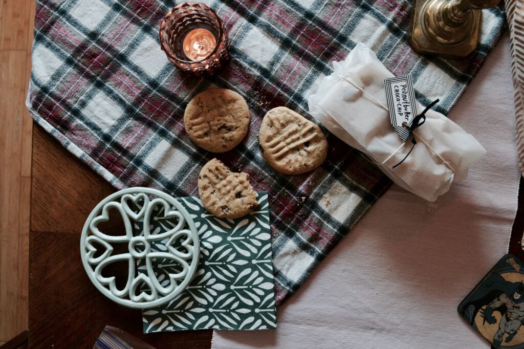 Un décor de table vintage à carreaux avec des biscuits, une lumière de bougie et des éléments décoratifs.