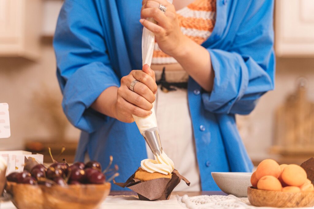 Prise de vue en gros plan de la décoration d'un cupcake avec du glaçage à la crème fouettée, entouré de fruits frais.