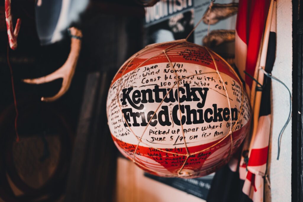Un ballon de basketball vintage avec la marque Kentucky Fried Chicken suspendu à l'intérieur, entouré d'une décoration éclectique.