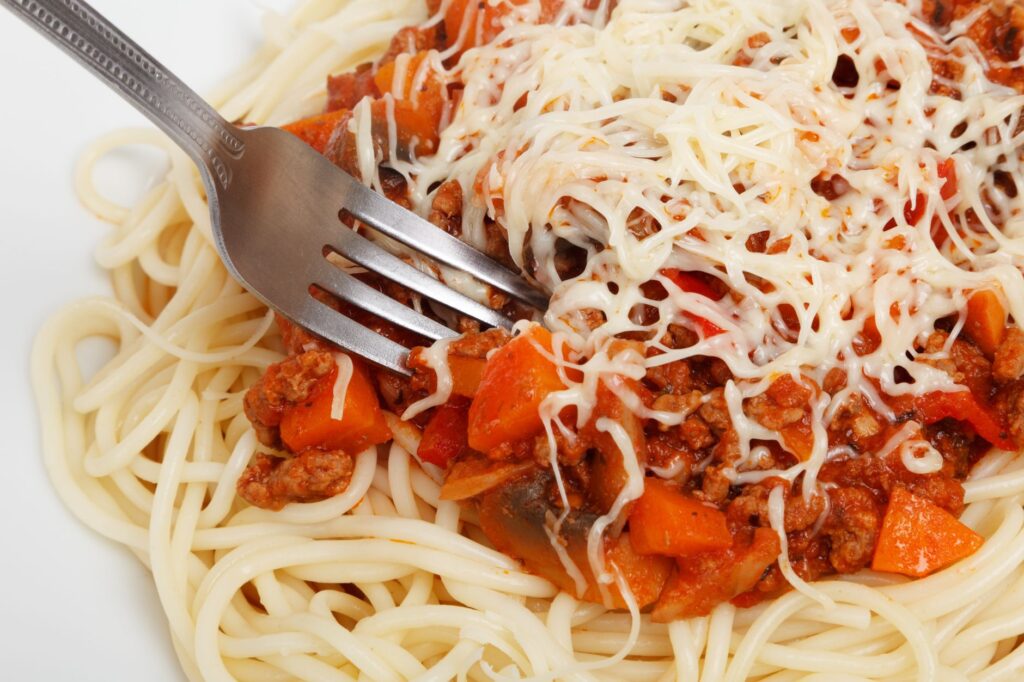 Gros plan sur de délicieuses spaghettis garnies de sauce bolognaise et de fromage.