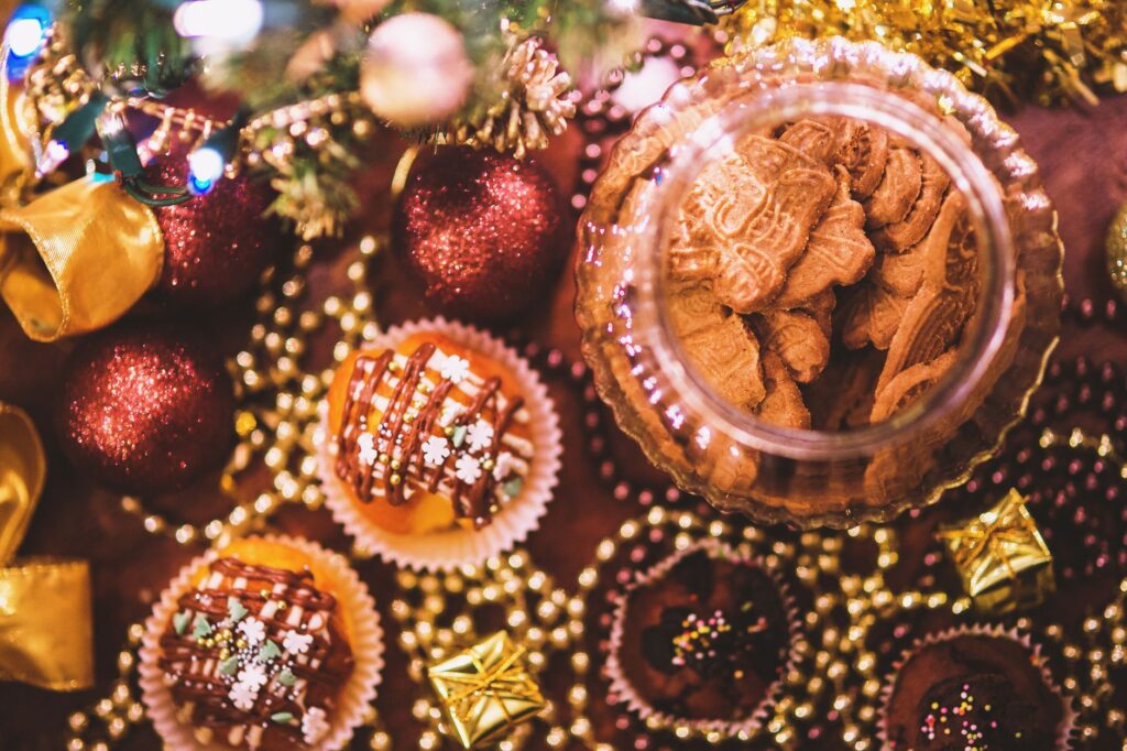 Une vue de dessus de cupcakes et biscuits de Noël entourés de décorations festives.
