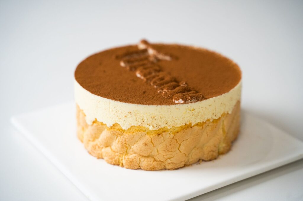 Gros plan d'un délicieux gâteau tiramisu avec des couches crémeuses et une poudre de cacao.