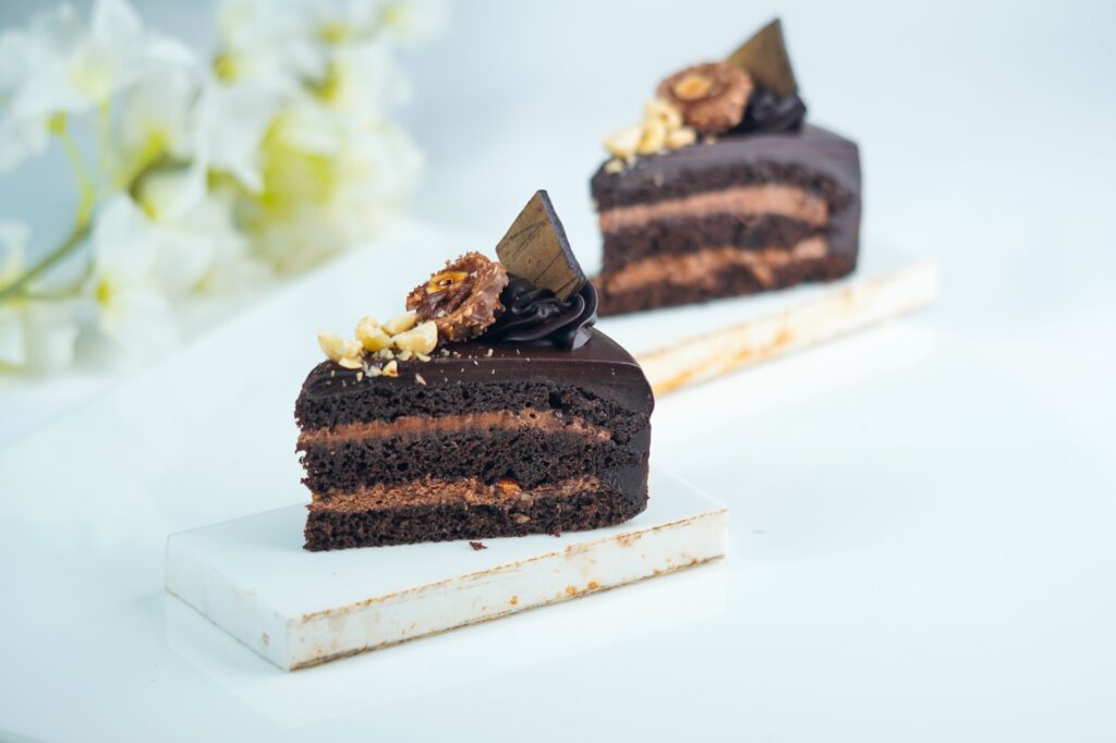 Gros plan sur deux tranches de gâteau au chocolat décadentes avec des couches riches et des garnitures décoratives.