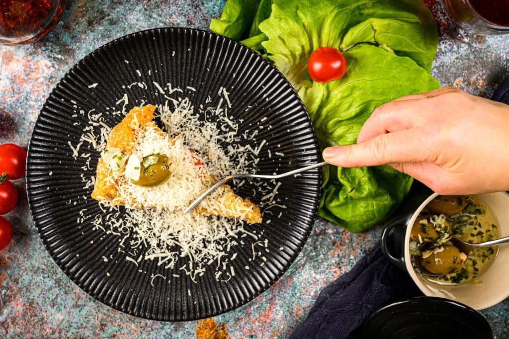 Délicieuse tranche de focaccia garnie de fromage et d'olives sur une assiette élégante.