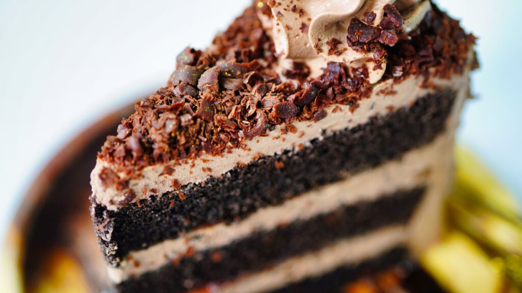Gros plan d'un gâteau à étages au chocolat décadent avec un glaçage riche, parfait pour les amateurs de desserts.