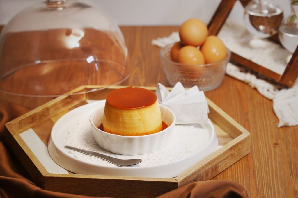 Délicieuse flan maison au caramel sur un plateau en bois dans une cuisine chaleureuse, parfait pour les amateurs de desserts.