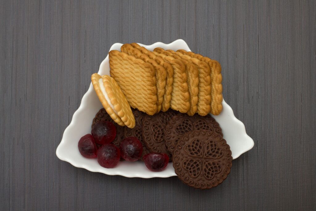 Gros plan de divers biscuits avec des bonbons colorés sur une assiette décorative.