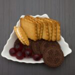 Gros plan de divers biscuits avec des bonbons colorés sur une assiette décorative.